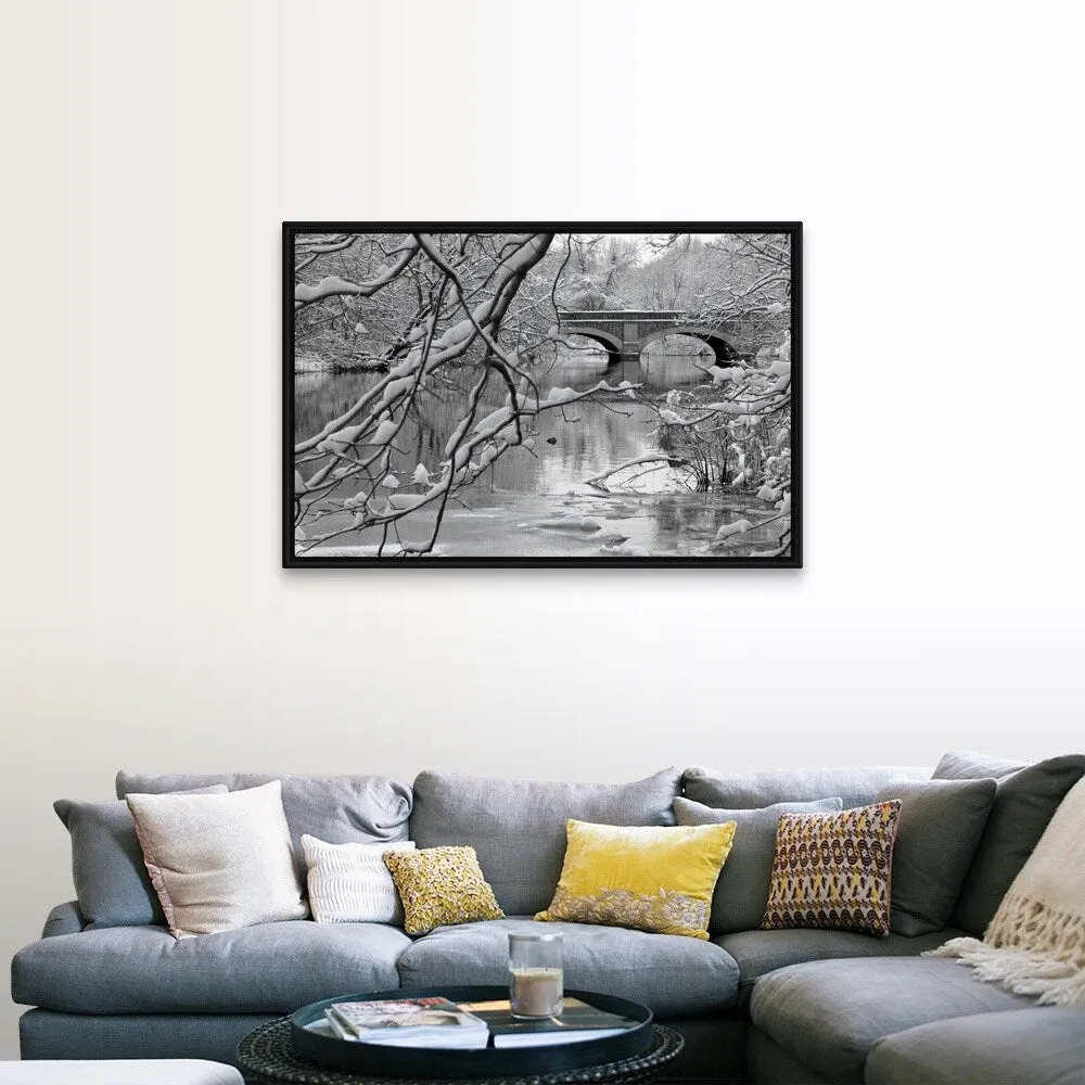 "Arch bridge over partially frozen river seen trough snow covered branches." Black Float Frame Canvas Art