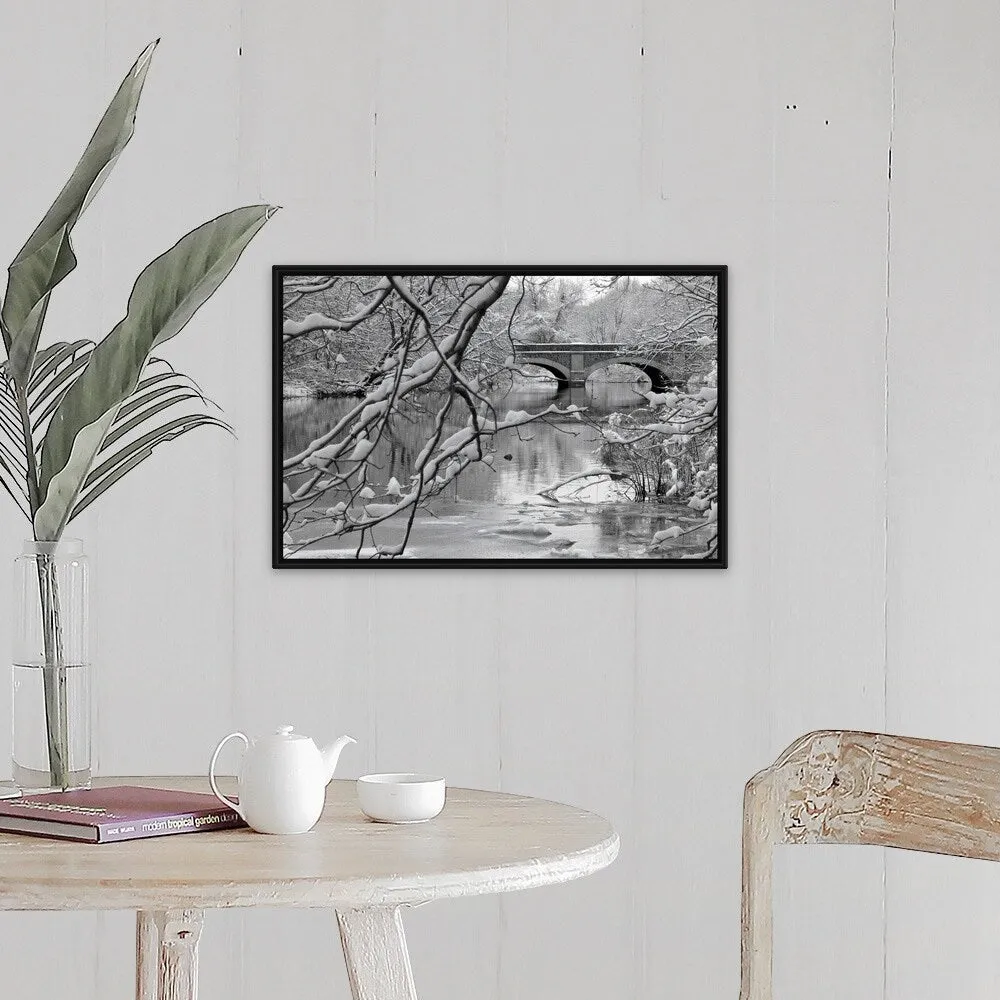 "Arch bridge over partially frozen river seen trough snow covered branches." Black Float Frame Canvas Art