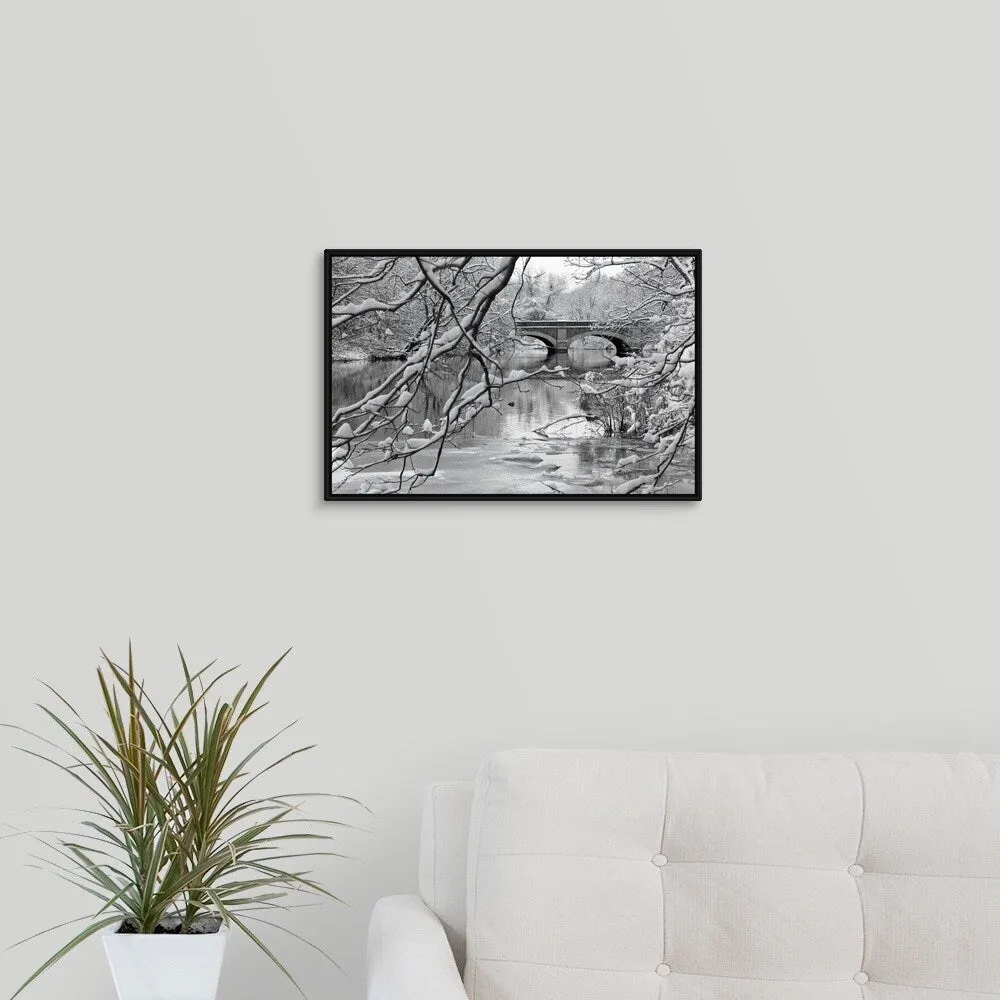 "Arch bridge over partially frozen river seen trough snow covered branches." Black Float Frame Canvas Art