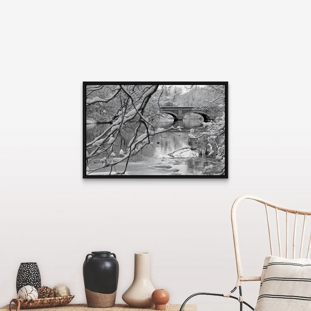 "Arch bridge over partially frozen river seen trough snow covered branches." Black Float Frame Canvas Art